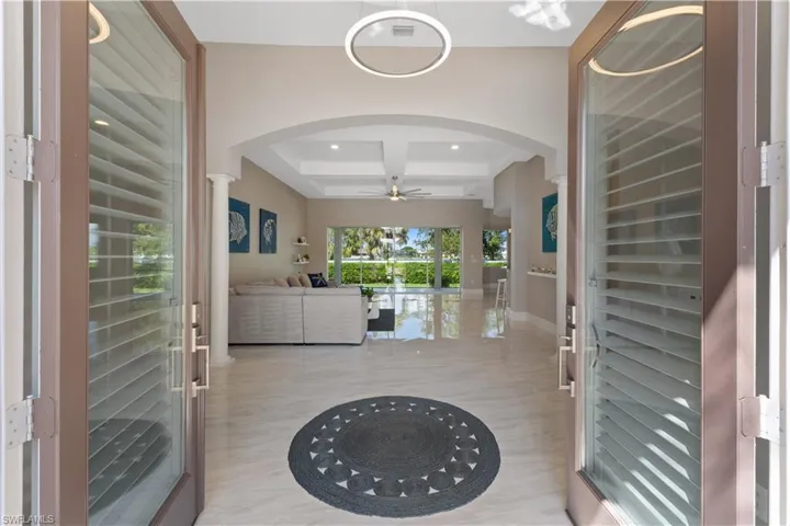 Entrance foyer featuring coffered ceiling and ceiling fan