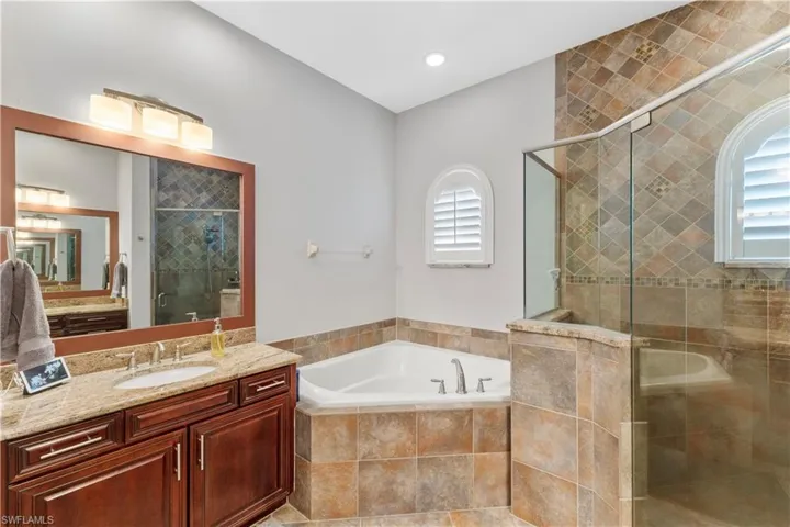 Bathroom featuring vanity and independent shower and bath
