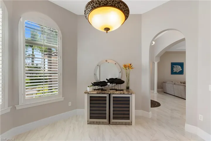 Bar featuring wine cooler and custom granite countertops