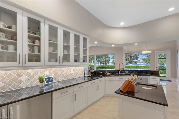 Kitchen with recessed lighting, a center island, sink, decorative backsplash, and white modern cabinetry