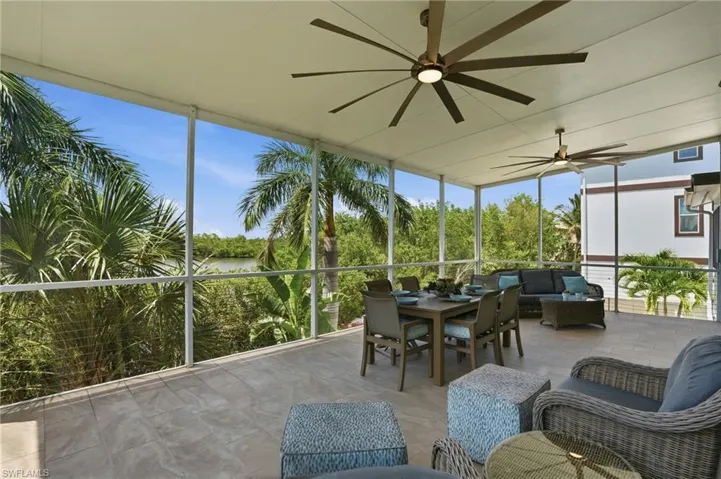 Expansive screened lanai with tile flooring and multiple ceiling fans - Virtually Edited Image