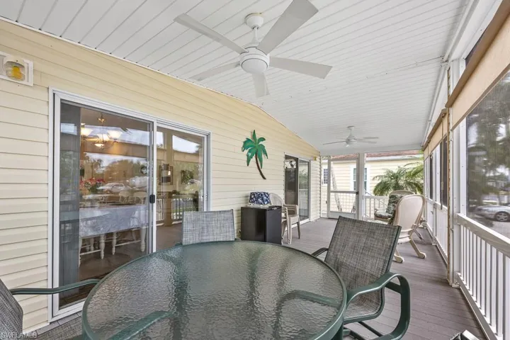 Sunroom featuring outdoor dining area, ceiling fan, vaulted ceiling, and a deck