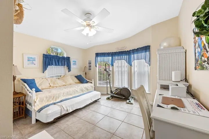 Bedroom with light tile patterned floors and a ceiling fan