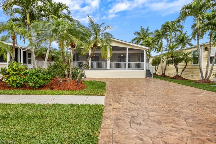 Back of house with a lawn and a sunroom