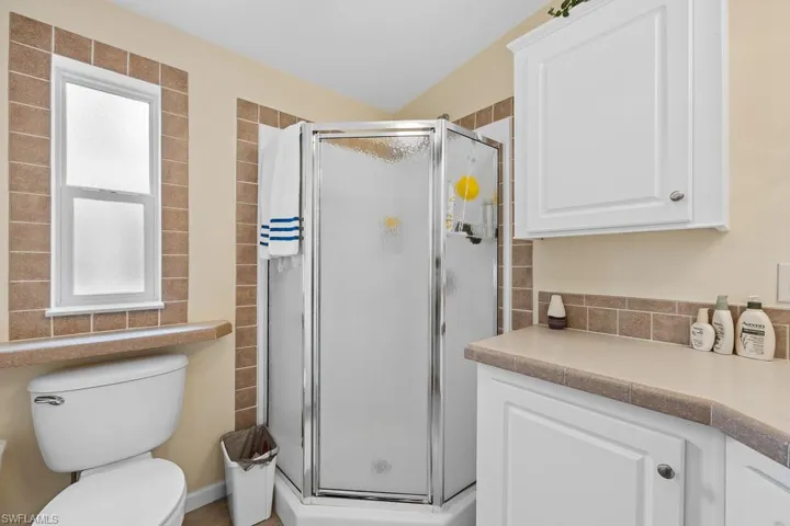 Full bath with a shower stall and vanity