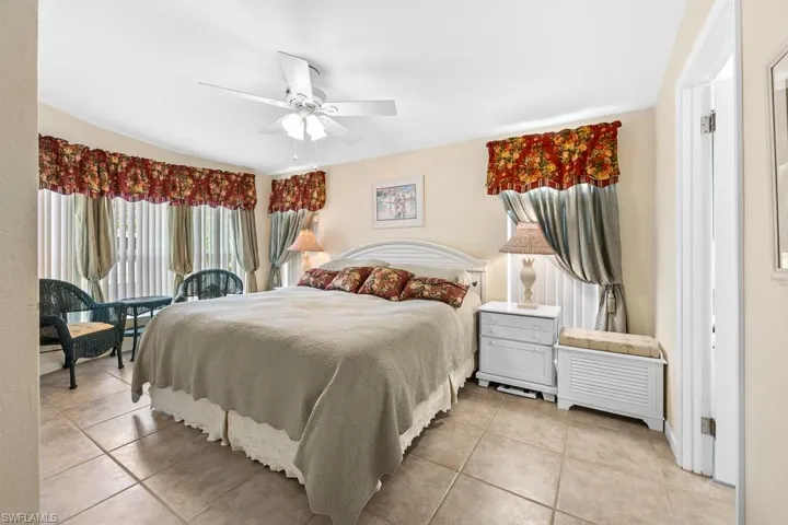 Bedroom with light tile patterned floors and a ceiling fan