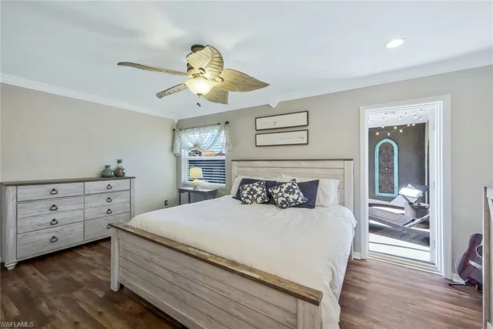 Bedroom with crown molding, ceiling fan, and dark hardwood / wood-style floors