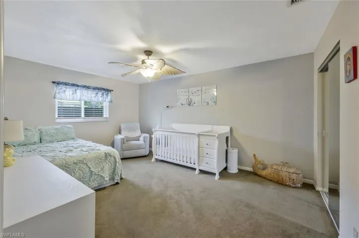 Carpeted bedroom featuring a closet and ceiling fan