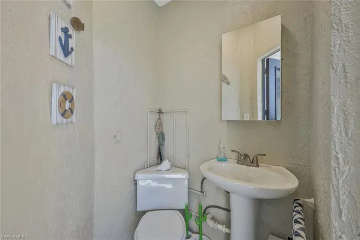 Pool Bathroom featuring toilet & sink