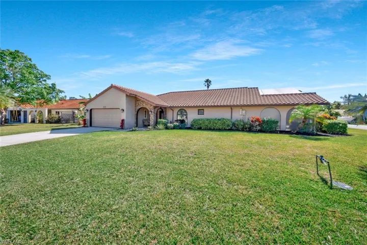 View of front of property featuring a garage and a front yard