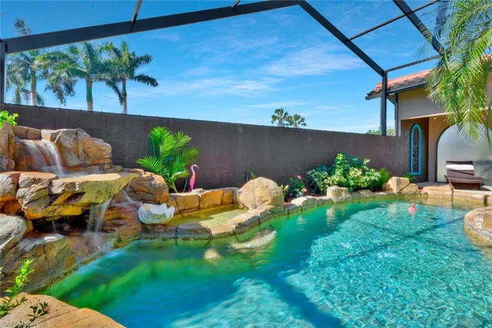 View of pool featuring pool water feature and screen enclosure