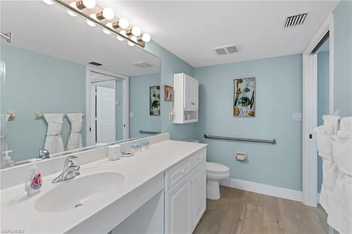 Bathroom with visible vents, wood finished floors, and vanity