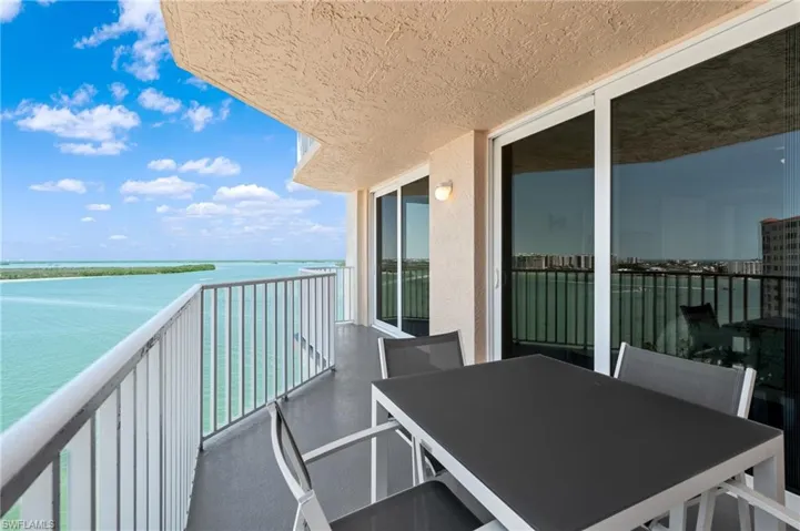 Balcony featuring outdoor dining area and a water view