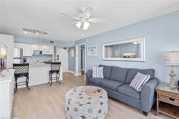Living area featuring a ceiling fan, visible vents, and light wood-type flooring