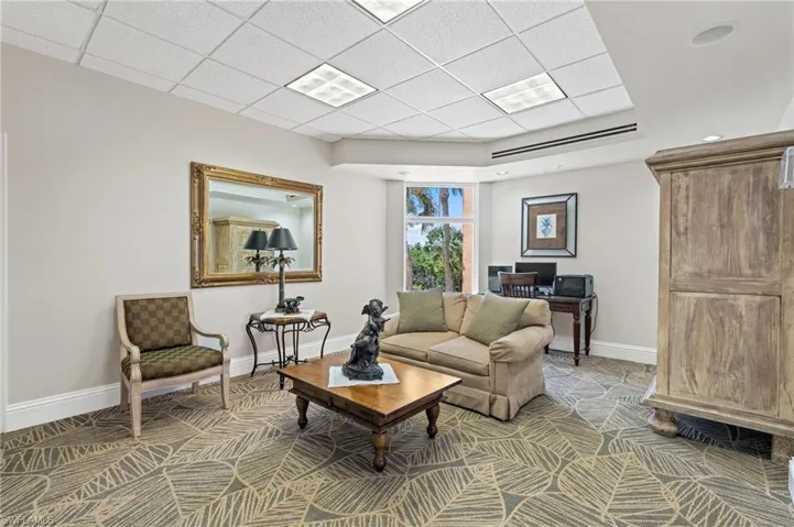 community room paneled ceiling, baseboards, and carpet floors