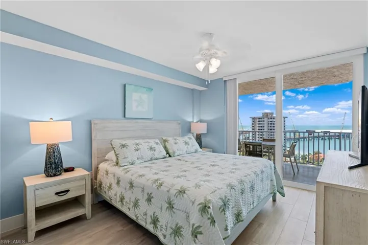 Bedroom featuring wood finished floors, access to outside, and floor to ceiling windows