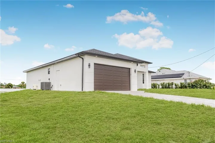 Garage featuring a yard and central AC