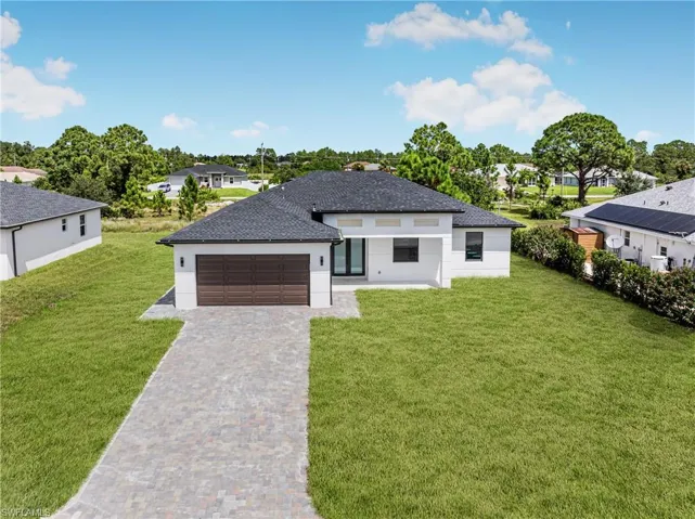 View of front of property featuring a garage and a front yard