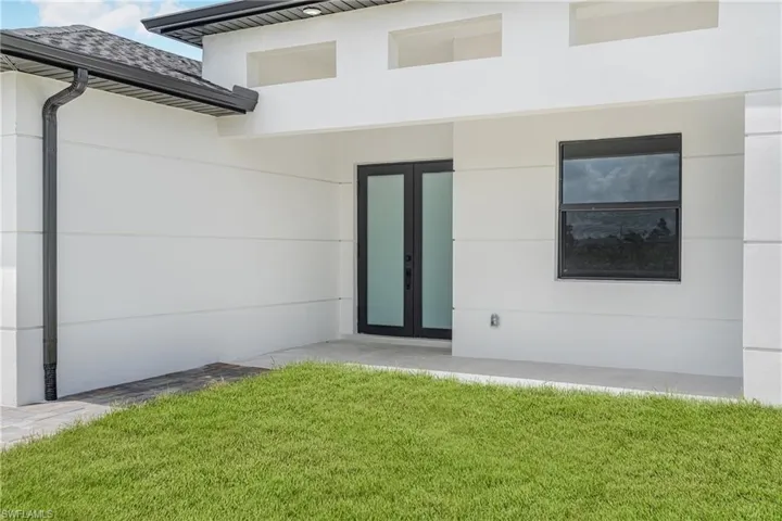 Entrance to property featuring a lawn and french doors
