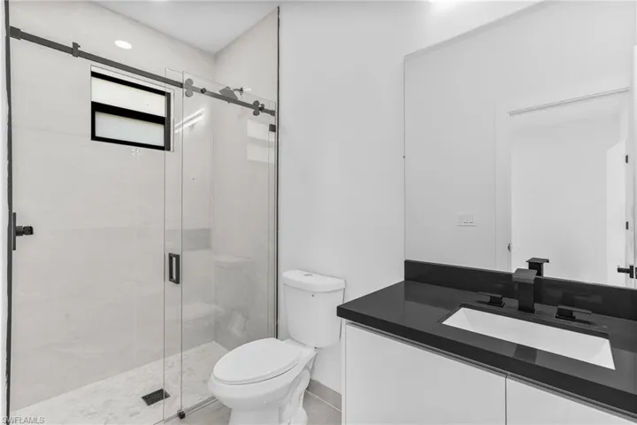 Bathroom featuring vanity, toilet, and walk in shower