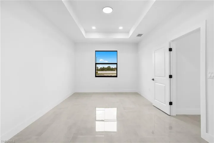 Empty room featuring a tray ceiling