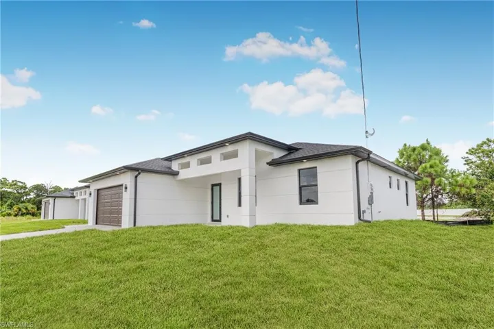 View of front of house featuring a front lawn and a garage