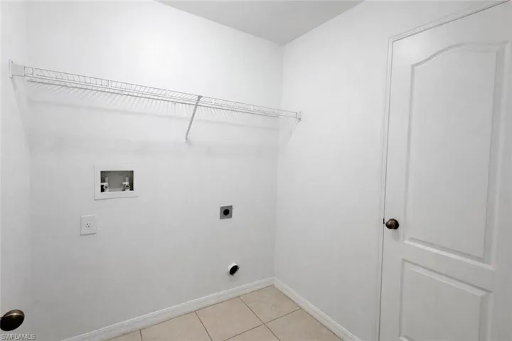 Laundry room with light tile patterned floors, washer hookup, and electric dryer hookup