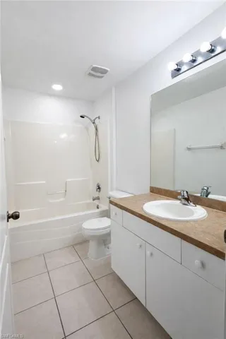 Full bathroom with vanity, bathtub / shower combination, and light tile patterned floors