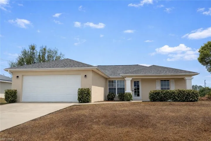 Ranch-style home featuring stucco siding, concrete driveway, an attached garage, and roof with shingles