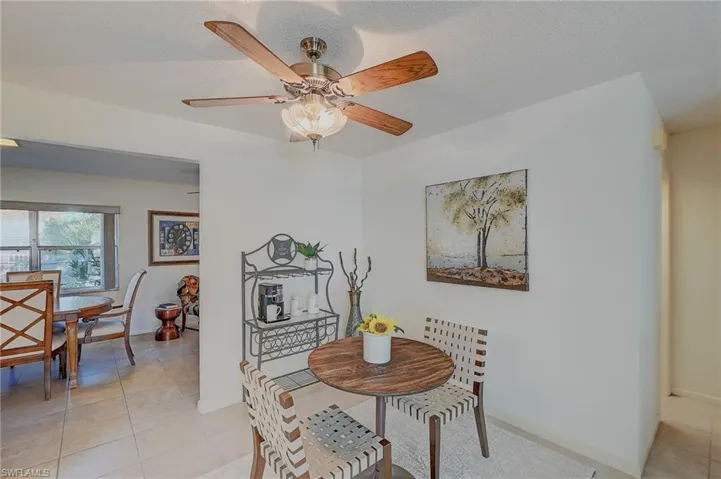 Tiled dining space featuring ceiling fan and a textured ceiling