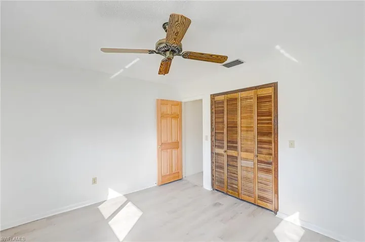 Unfurnished bedroom with a closet, ceiling fan, and light wood-type flooring