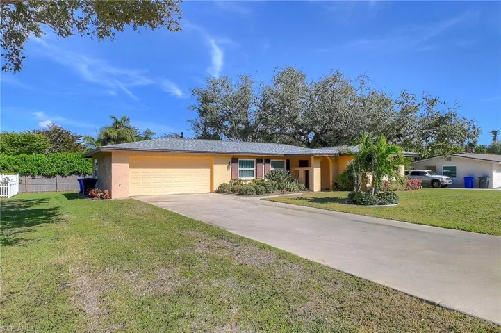 Single story home featuring a garage and a front lawn