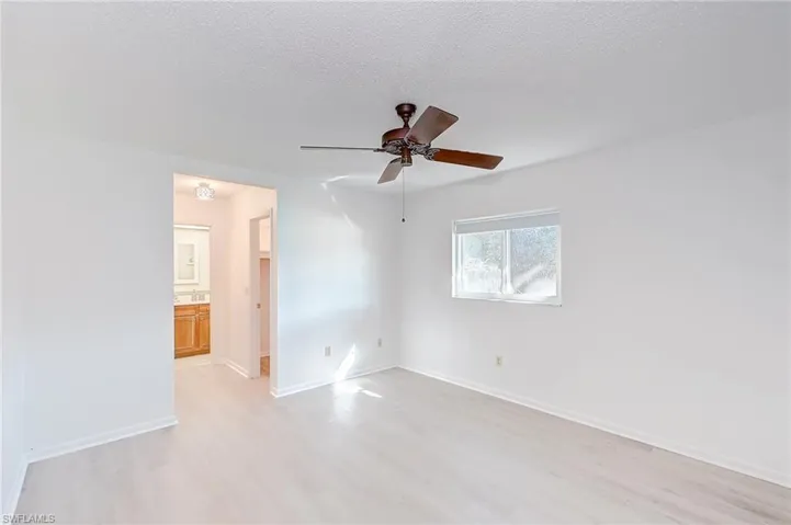 Spare room featuring ceiling fan, a textured ceiling, and light wood-type flooring