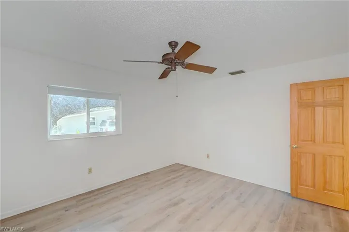 Unfurnished room featuring ceiling fan, a textured ceiling, and light hardwood / wood-style floors
