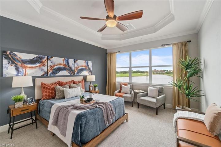 Primary bedroom has a rich slate blue accent wall and highlighted by a beautiful tray ceiling.