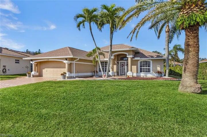 Mediterranean / spanish home featuring a garage and a front yard