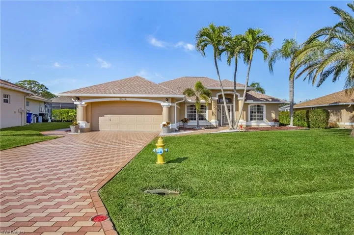 Single story home with a garage and a front lawn
