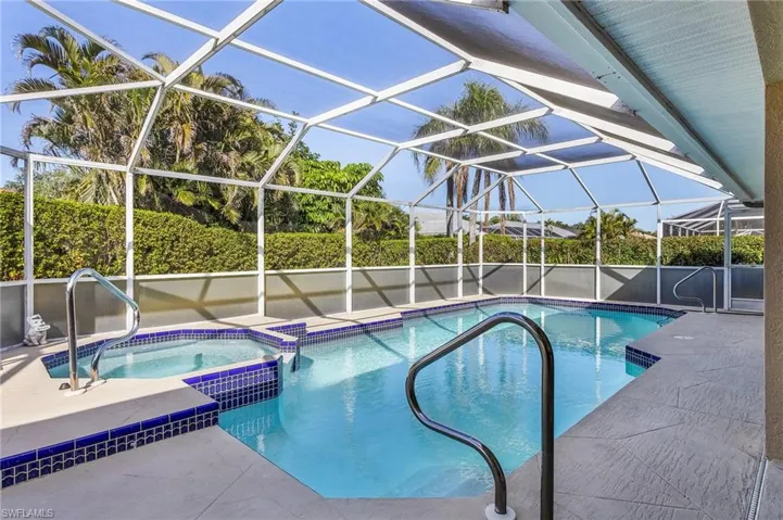 View of swimming pool with an in ground hot tub, a lanai, and a patio