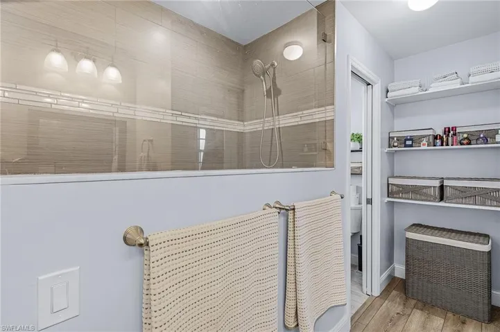 Bathroom featuring wood-type flooring and tiled shower