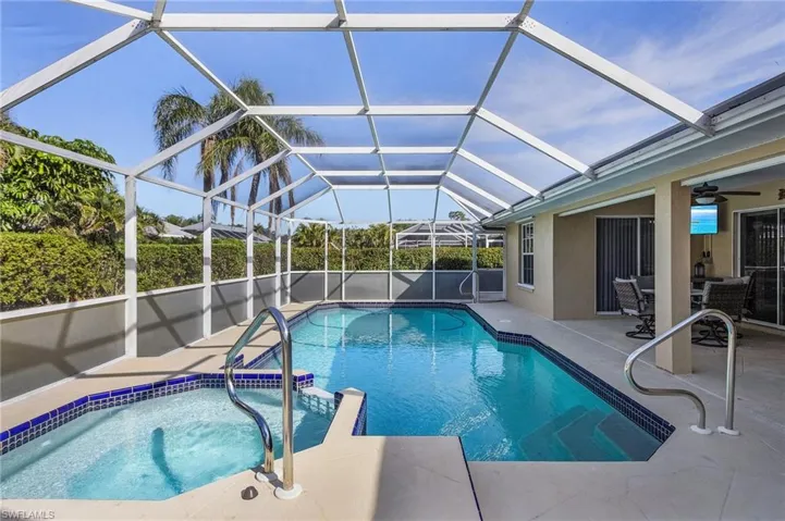 View of swimming pool featuring ceiling fan, a patio, and glass enclosure