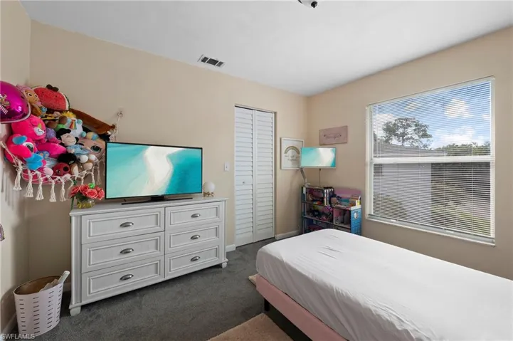 Carpeted bedroom featuring a closet