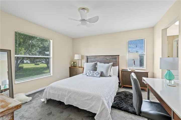 Carpeted bedroom featuring ceiling fan