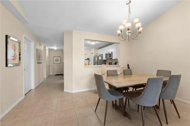 Dining area featuring light tile patterned floors and a chandelier