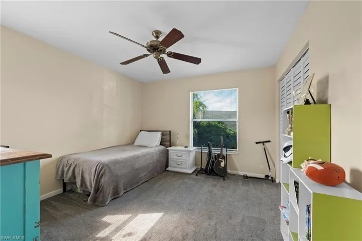 Carpeted bedroom featuring ceiling fan
