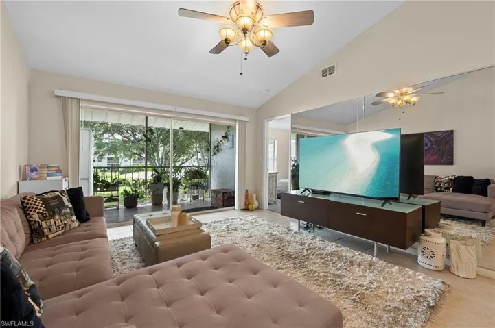 Living room featuring ceiling fan, light tile patterned floors, and high vaulted ceiling