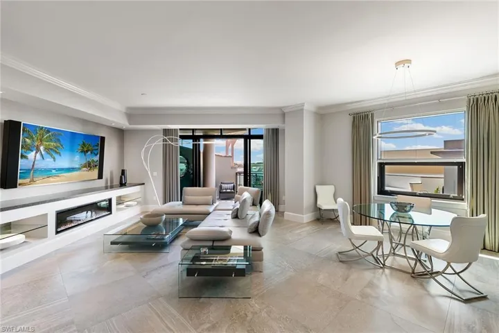 Living room featuring ornamental molding and a glass covered fireplace
