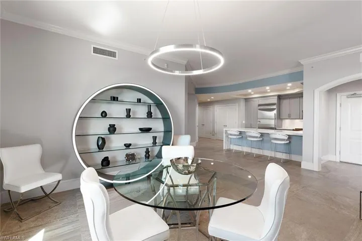 Dining space with crown molding and arched walkways