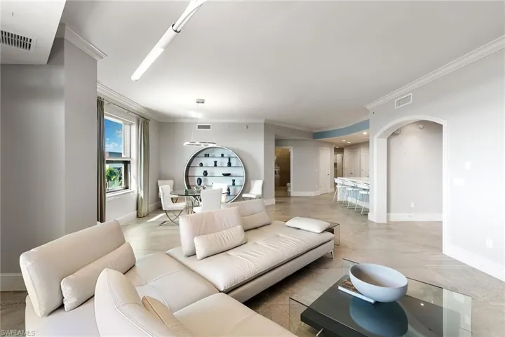 Living area with crown molding and arched walkways