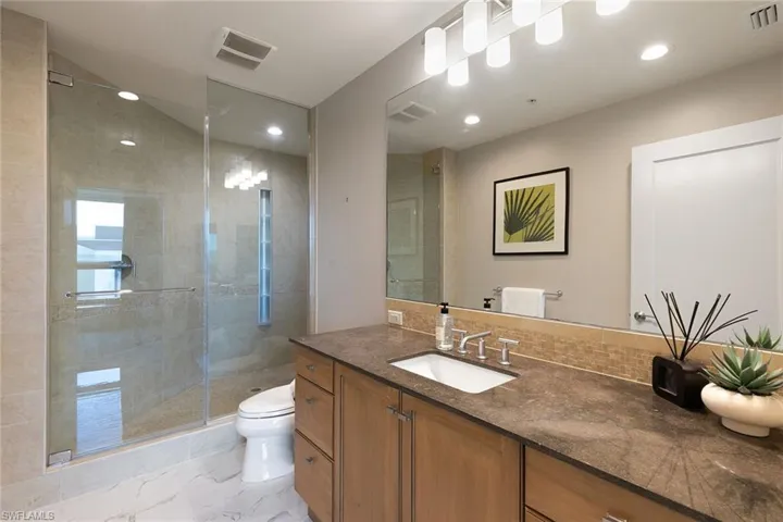Full bathroom featuring vanity, a stall shower, and recessed lighting
