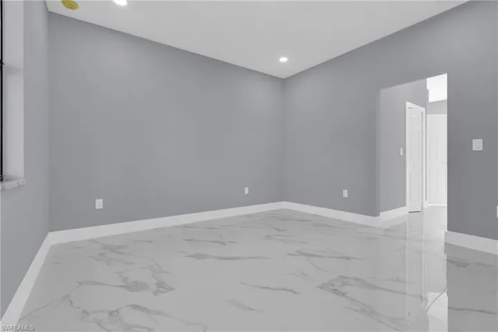 Unfurnished room with light marble finish floors and recessed lighting